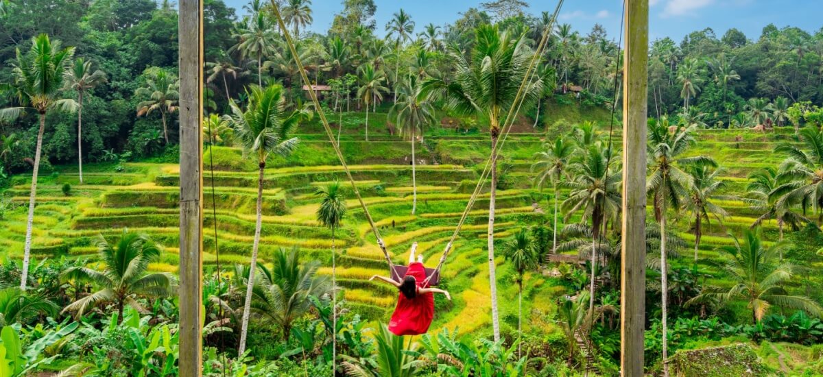 female-tourist-in-red-dress-enjoying-the-bali-swing