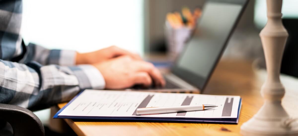 person-filling-out-application-using-laptop