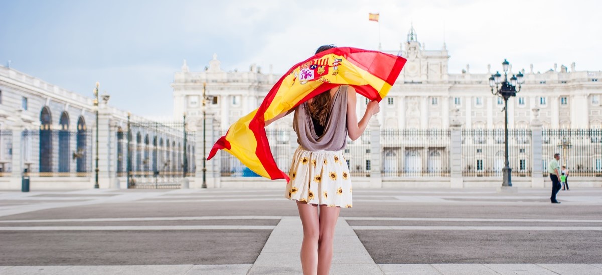 Woman with back to camera waving a Spanish flag