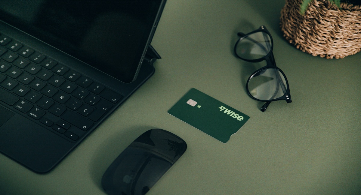 Ein Schreibtisch mit Laptop, Maus, Brille und der Wise Business-Debitkarte